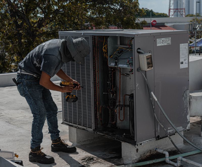 Technician servicing a rooftop HVAC unit